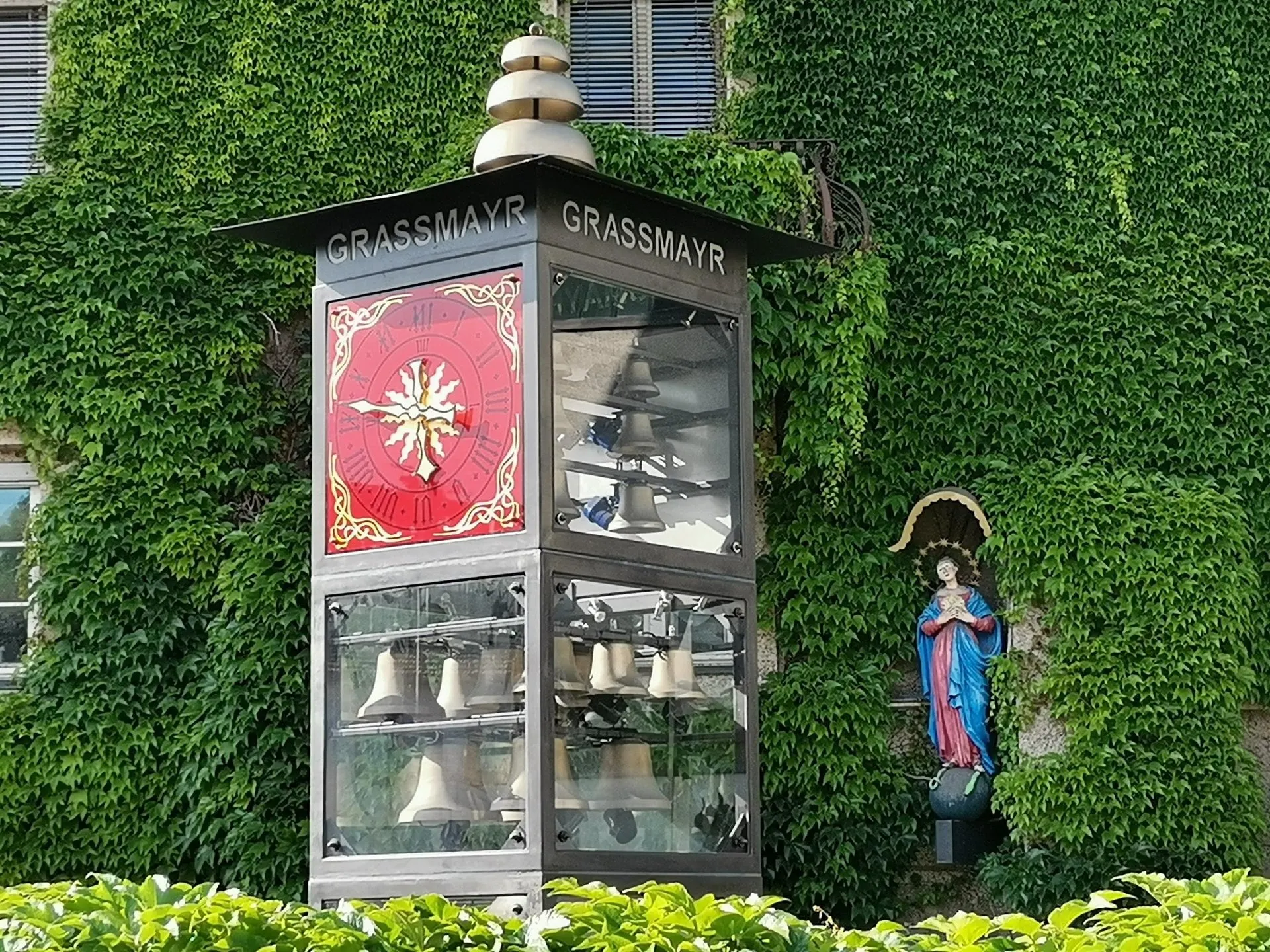 Grassmayr carillon tower with bells in front of an ivy covered wall