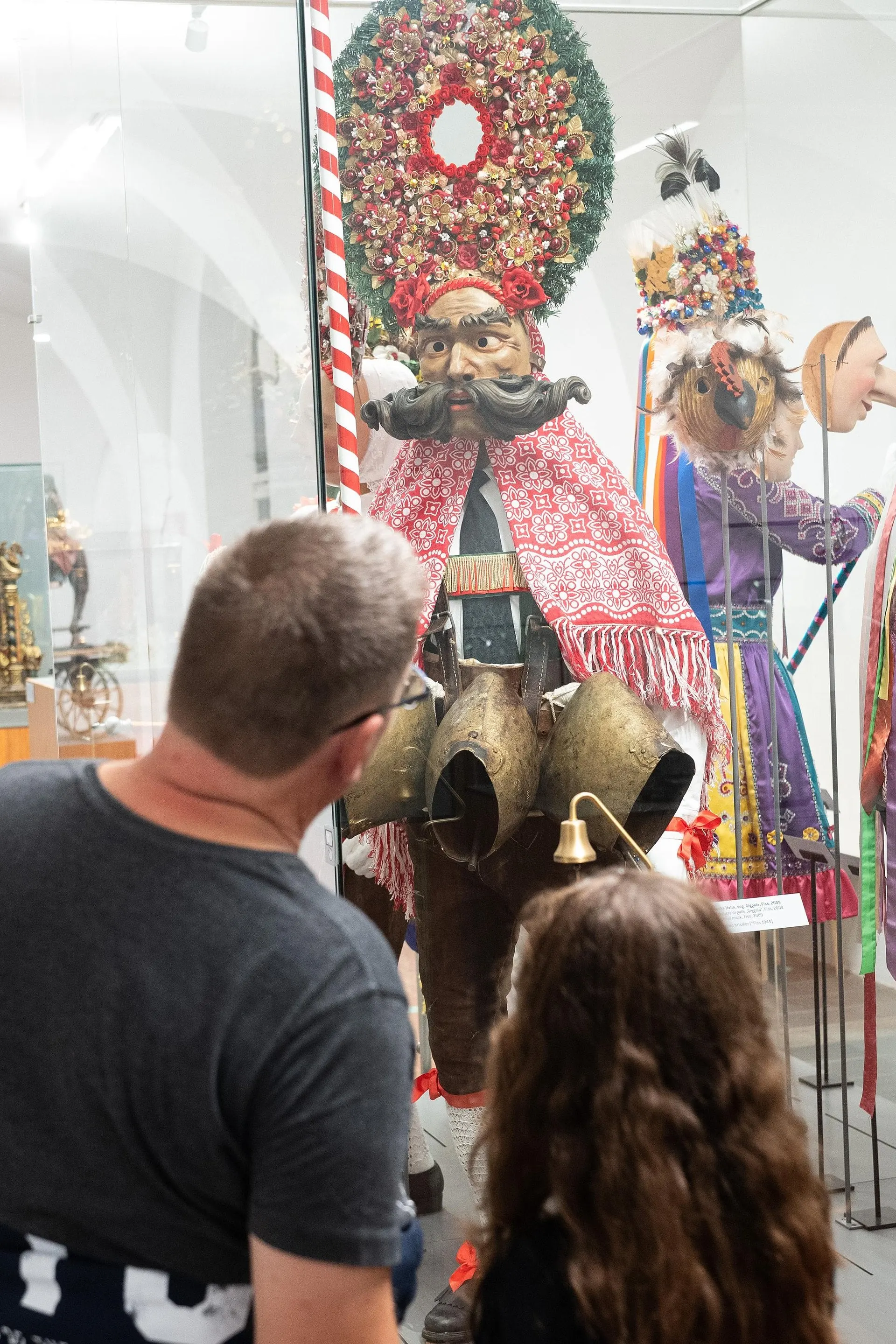 Visitor looking at carnival costumes and masks in the Tyrolean Folk Art Museum