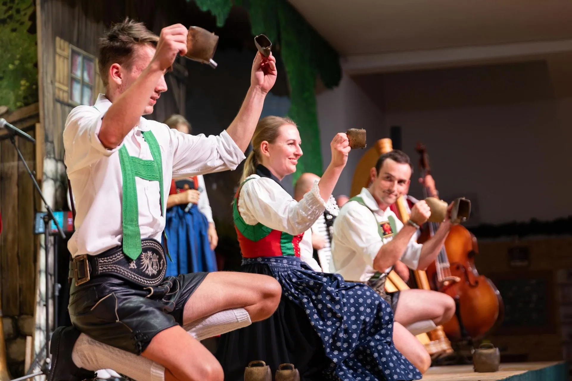 Performers playing cowbells on stage at the Tyrolean evening