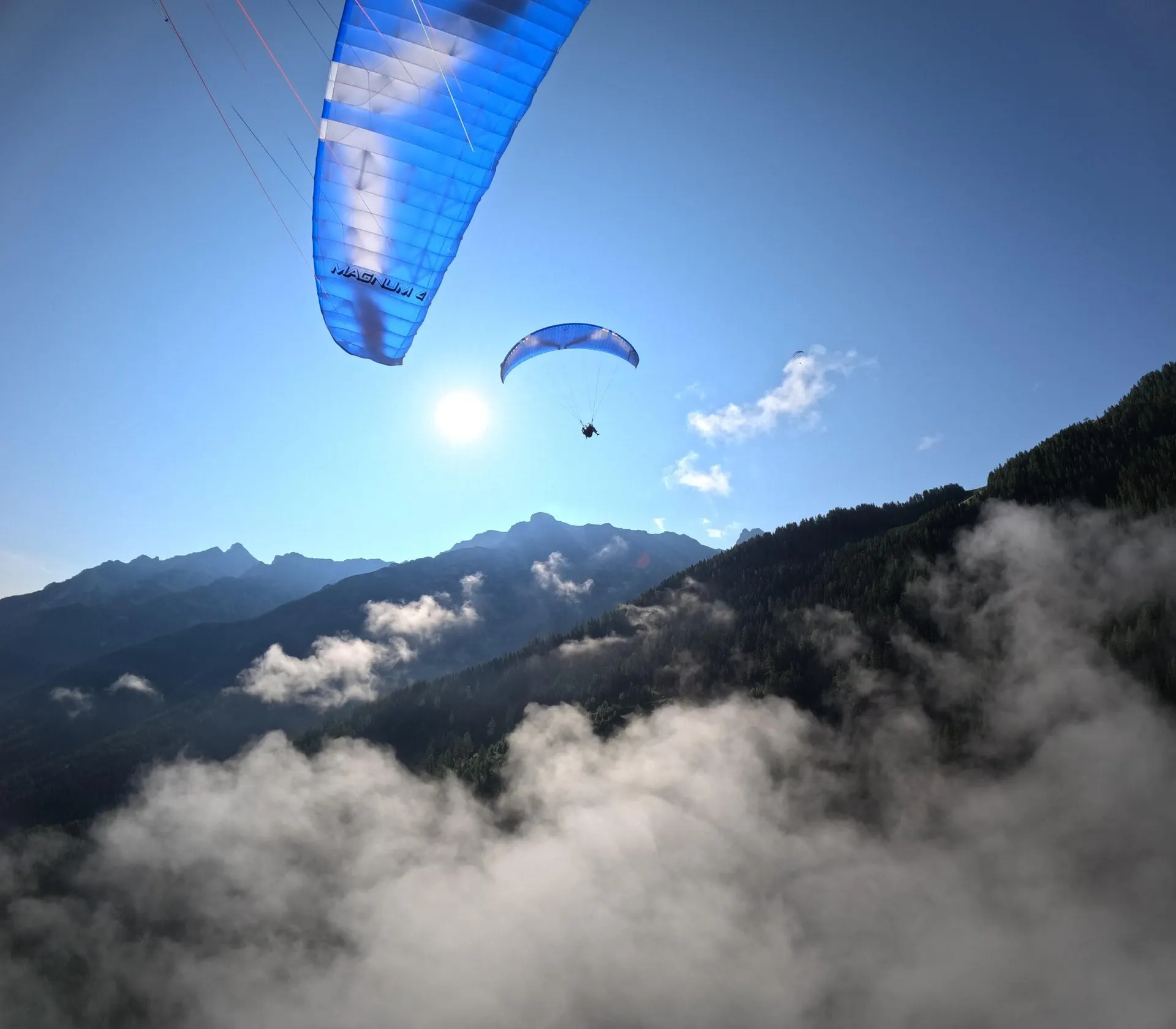 Paragliders above a sea of cloud in the Stubai Alps