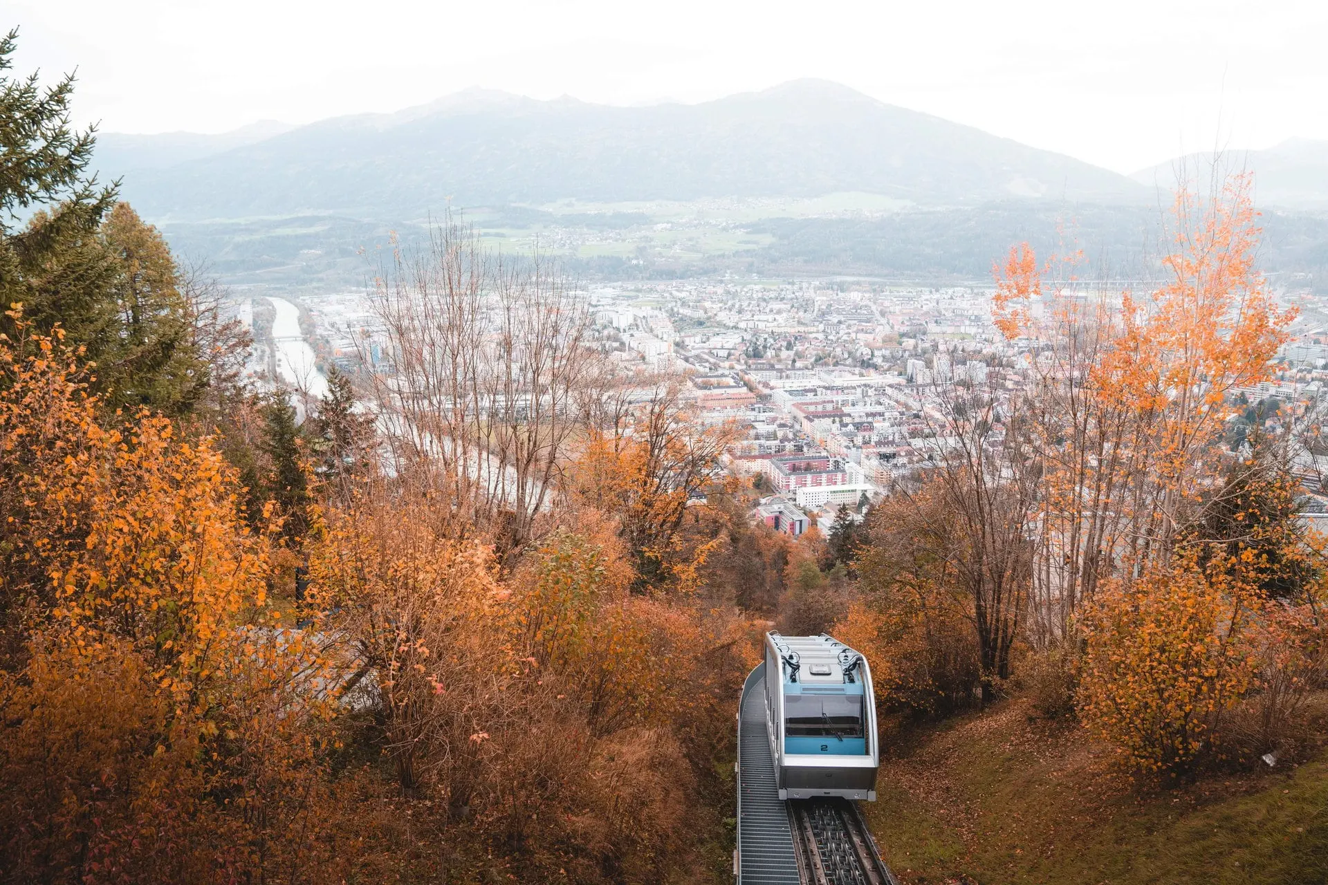 Hungerburg funicular car climbing through autumn trees above Innsbruck