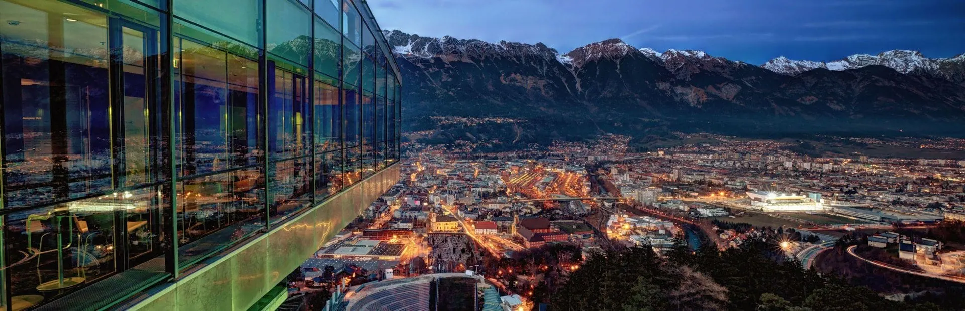 Innsbruck lit up at dusk from the Bergisel panorama café