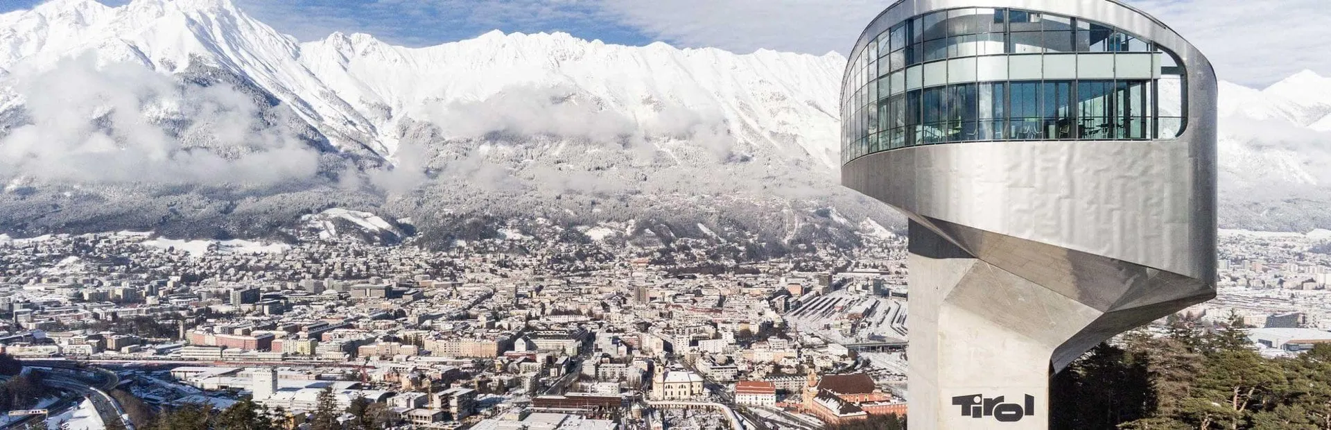 Bergisel tower above snowy Innsbruck with the Nordkette behind