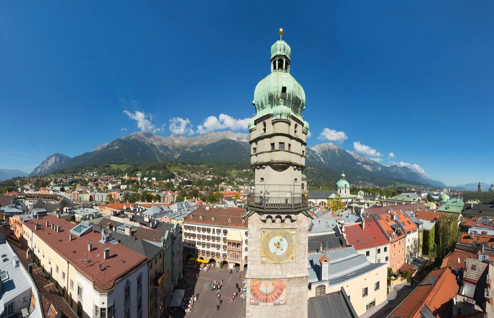 Innsbruck City Tower above the old town rooftops with mountains behind