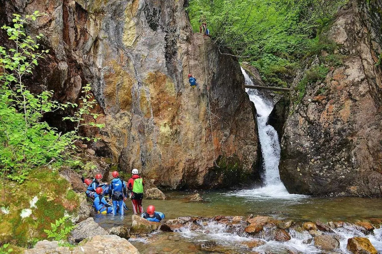 Canyoning group at the foot of a waterfall in the gorge
