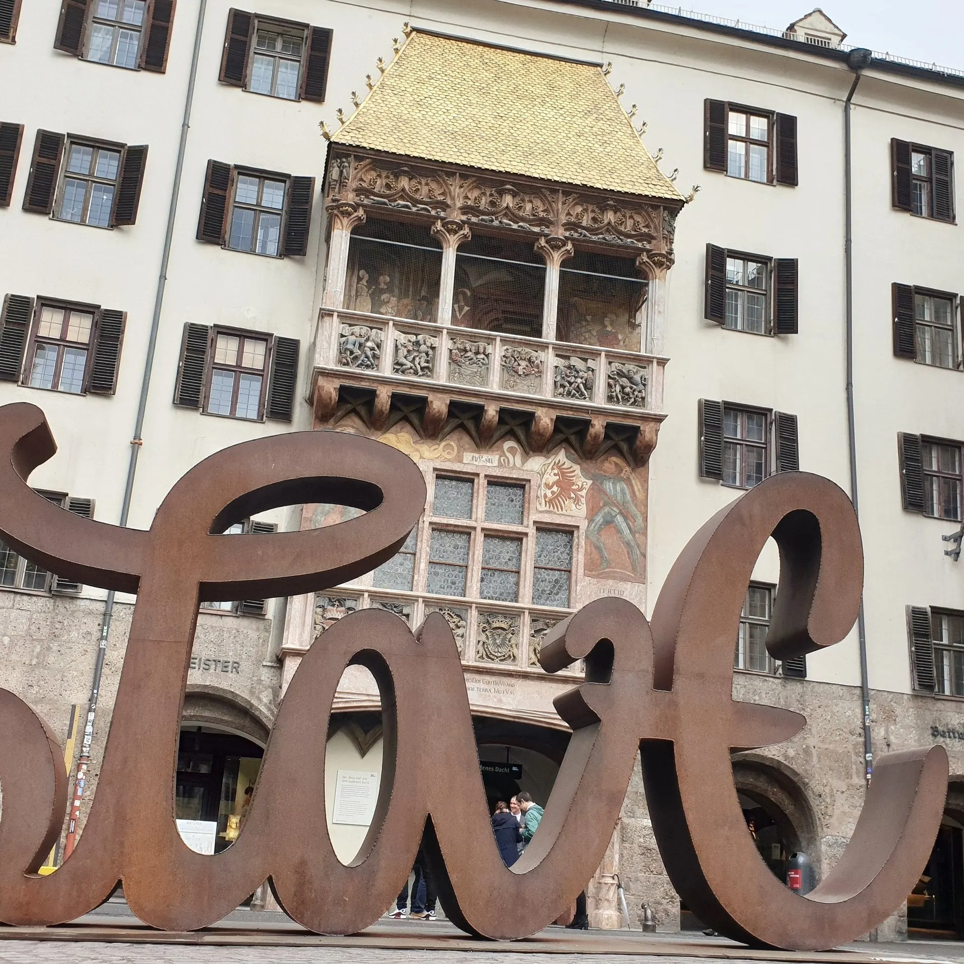Goldenes Dachl in der Innsbrucker Altstadt hinter einer großen Metallskulptur