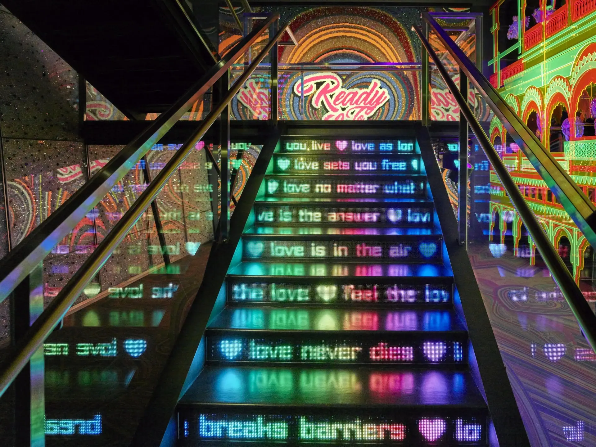 Neon staircase with love messages in a Crystal Worlds chamber