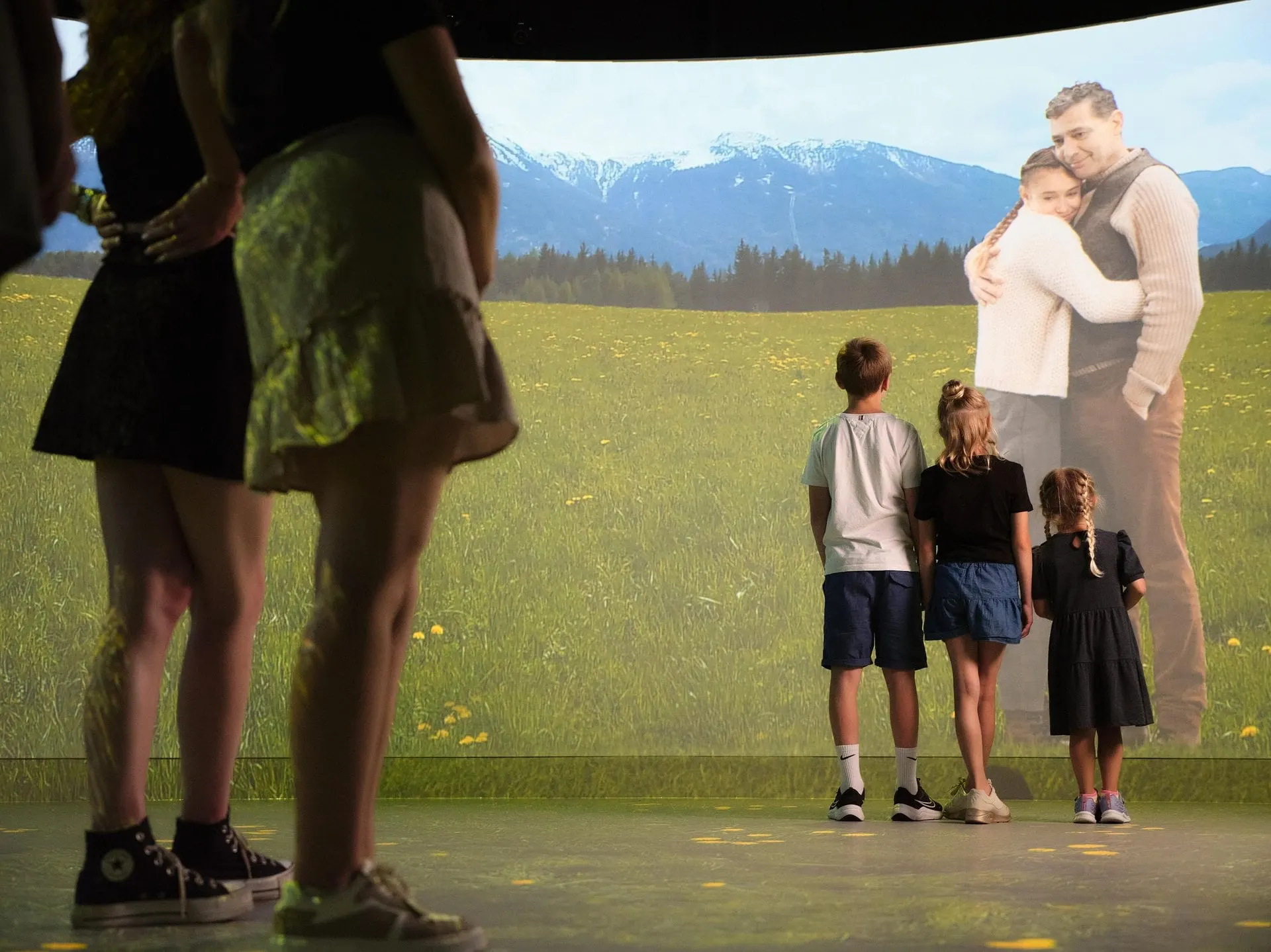 Family in front of an immersive alpine meadow projection at Experience Tirol