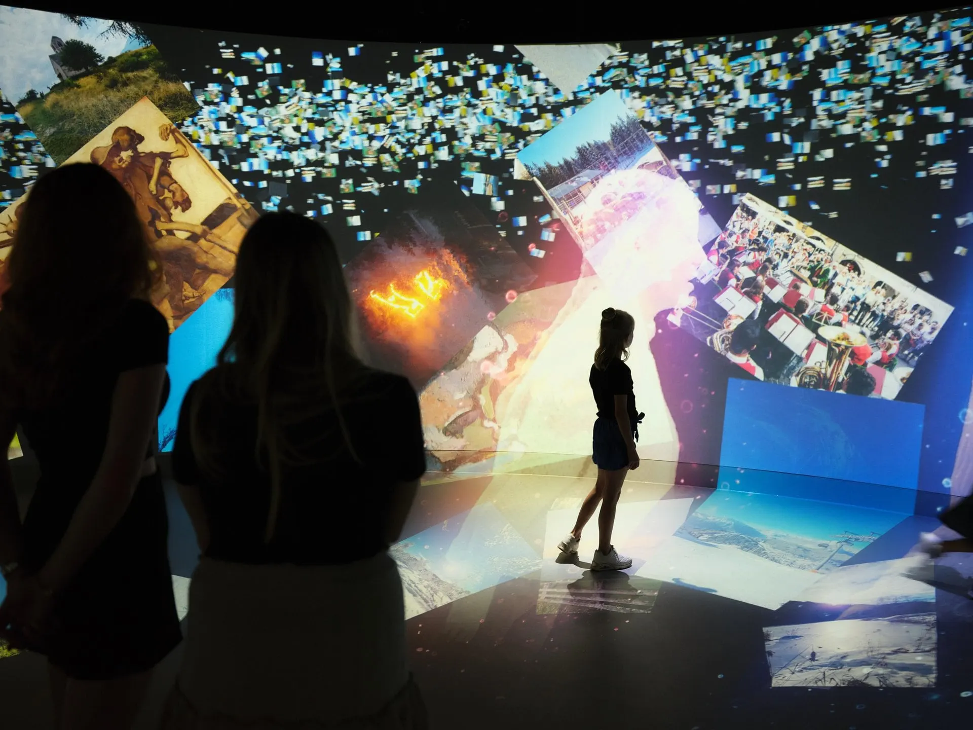 Visitors surrounded by projected photos at Experience Tirol