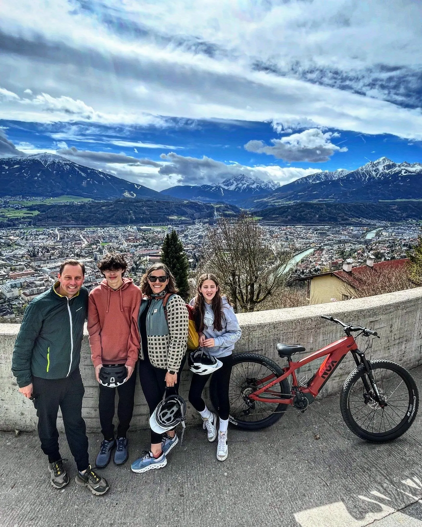 Family with electric bikes at a viewpoint above Innsbruck