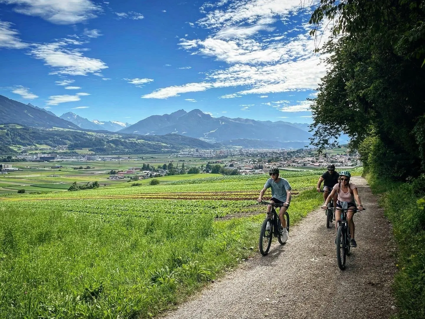 Electric bike riders on a farm track through Inn Valley fields