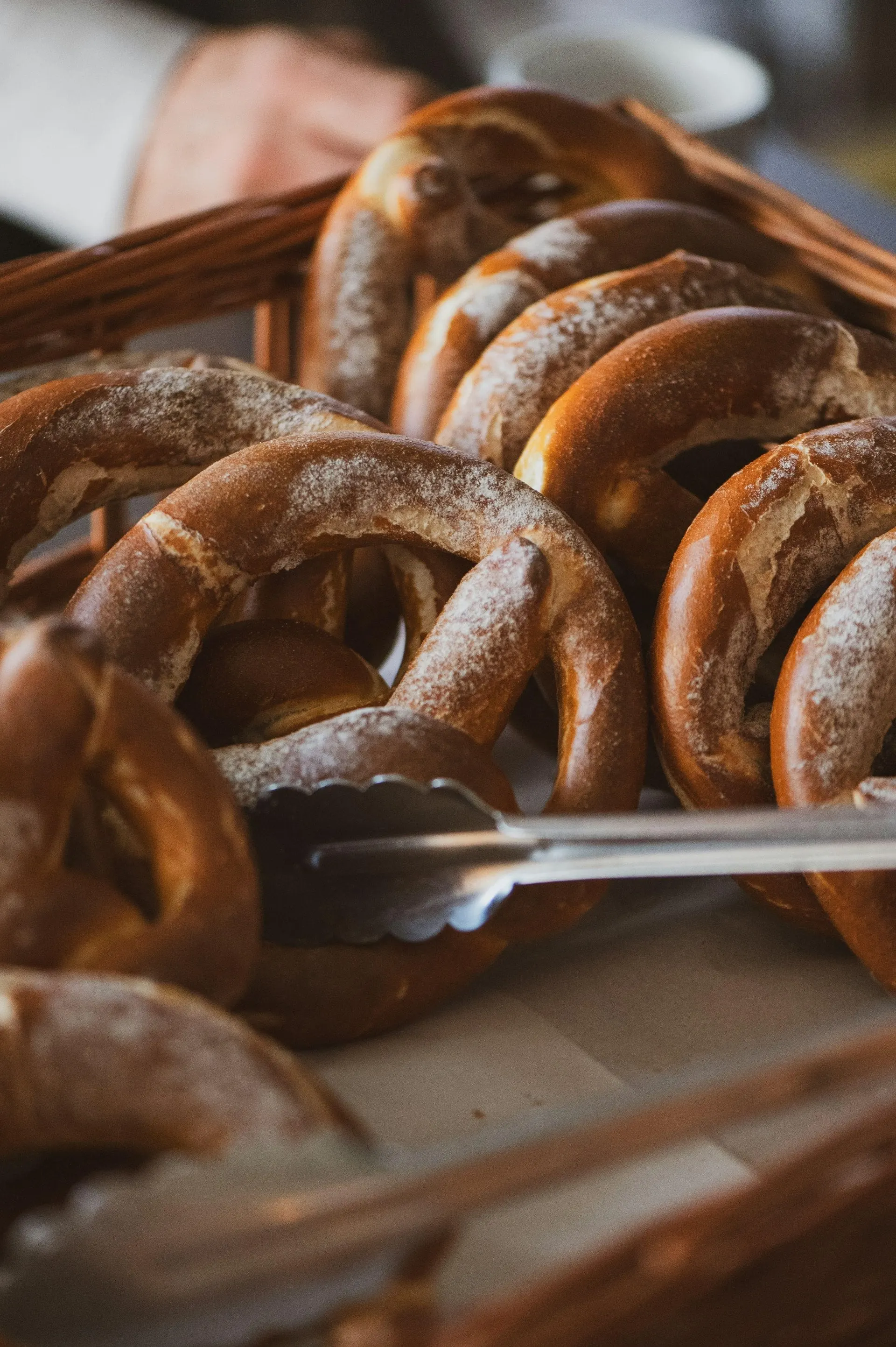 Soft pretzels in a basket with tongs