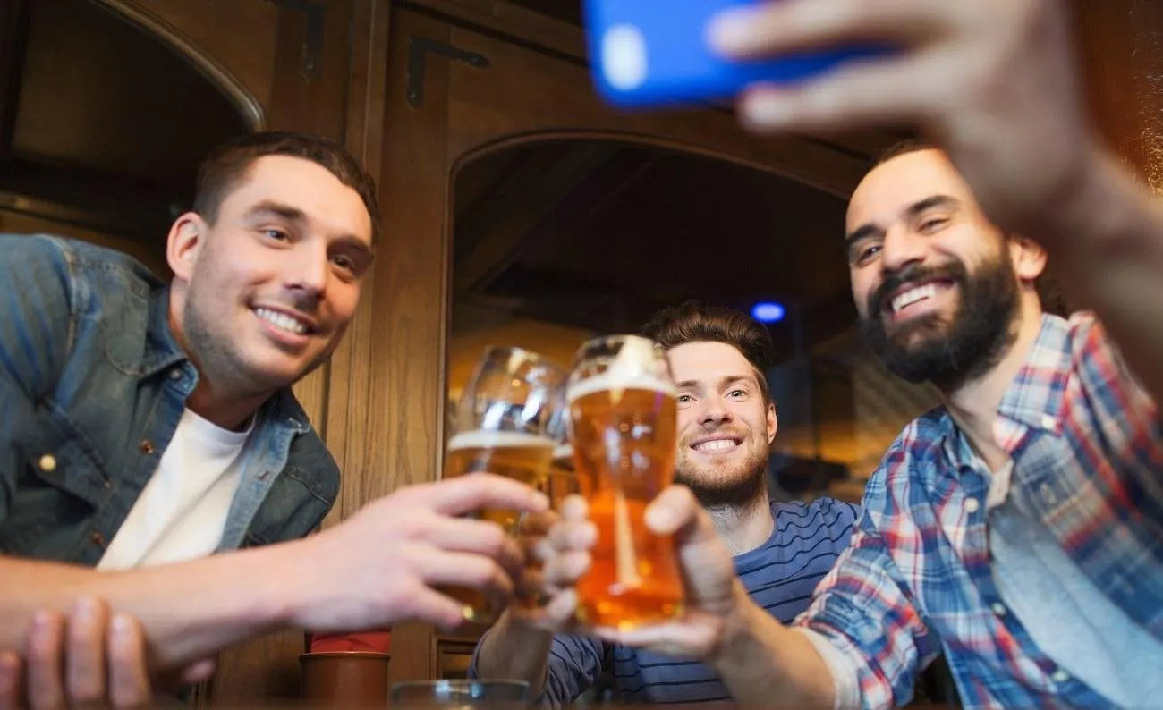 Friends toasting with beer and taking a selfie